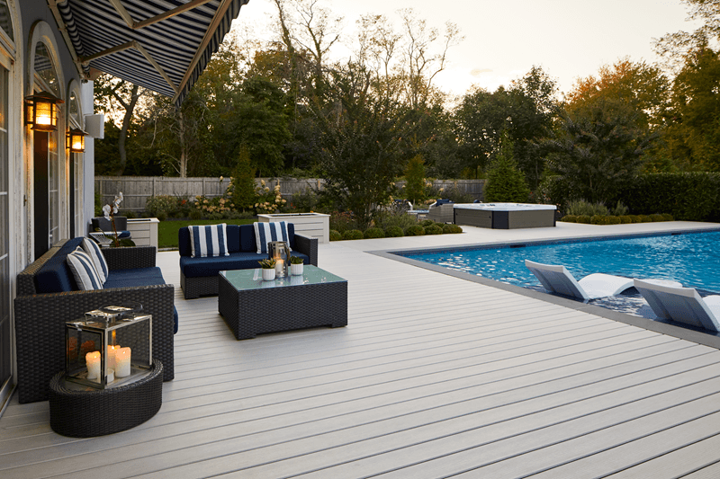 Outdoor living area with a composite deck, pool, hot tub, and patio furniture.